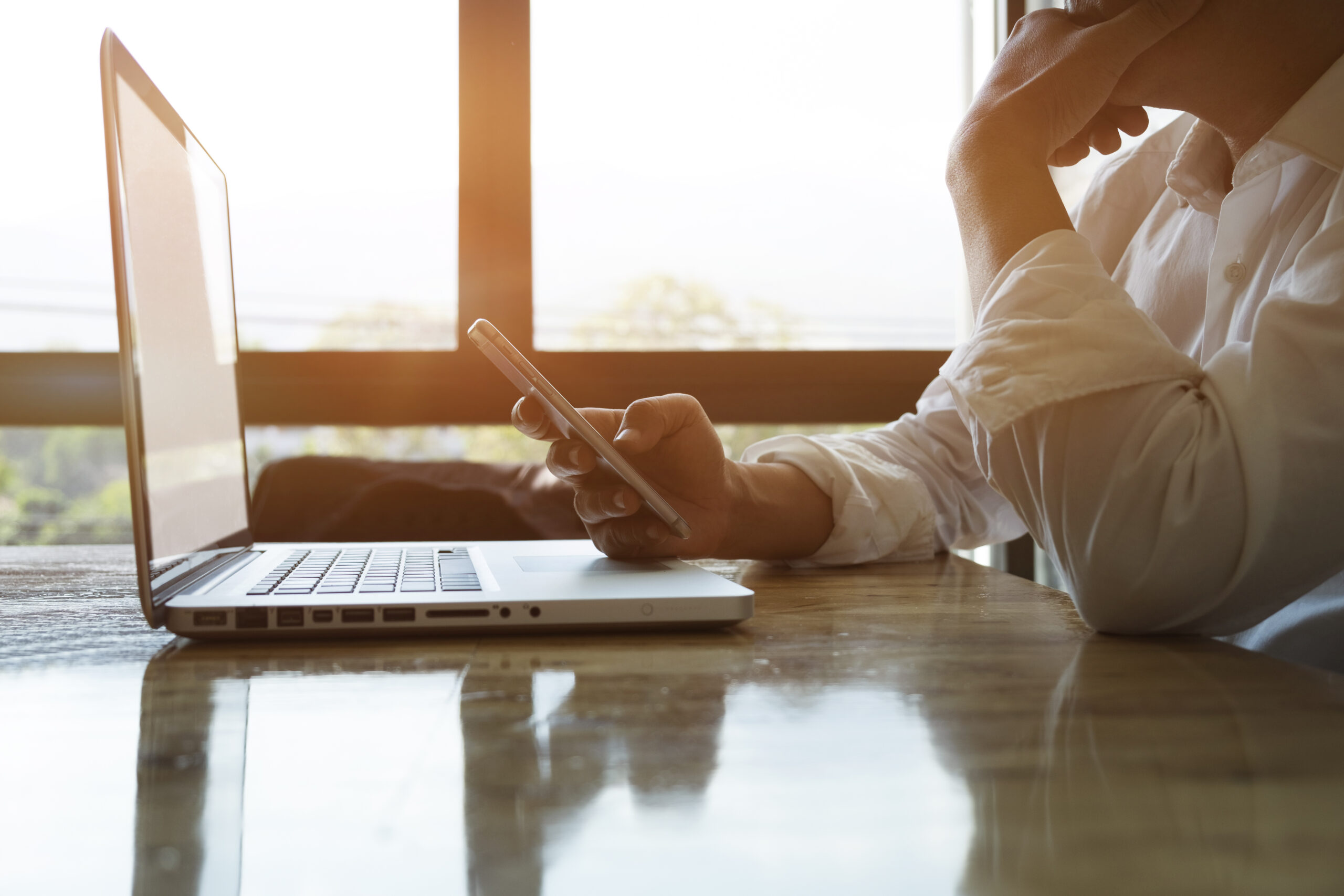 Thoughtful businessman or experienced entrepreneur using smartph